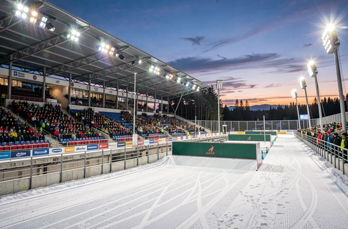Stade de biathlon éclairé par les projecteurs en fin d'après-midi
